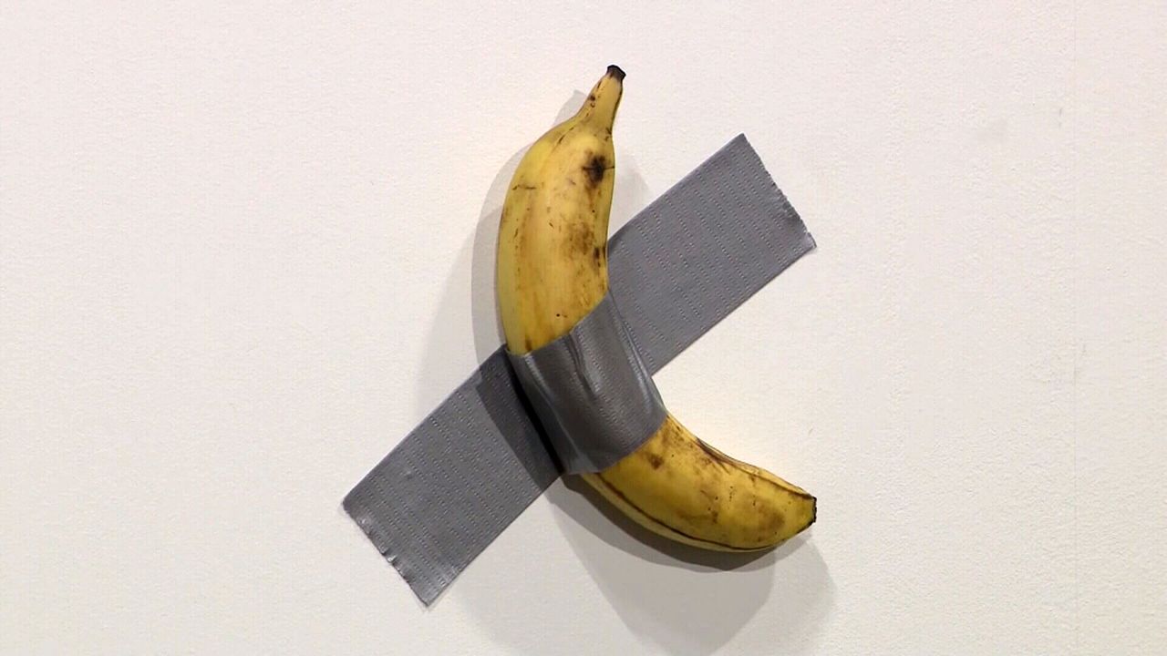 Artist David Datuna ate a banana from a 120,000 USD art installation. Image via CNN.