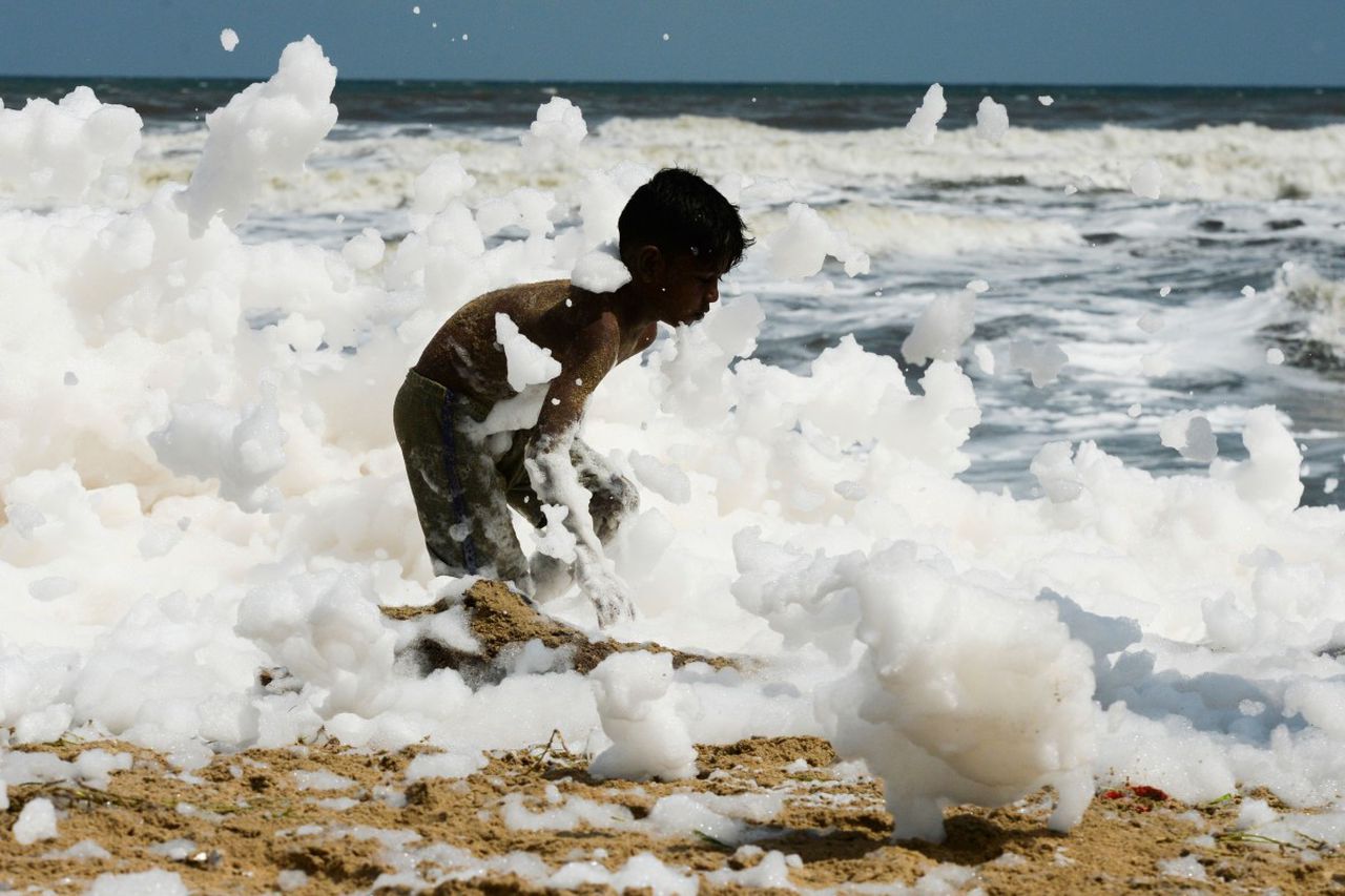 Toxic white foam has been washing up on Chennai's Marina Beach for four days. Image via AFP.