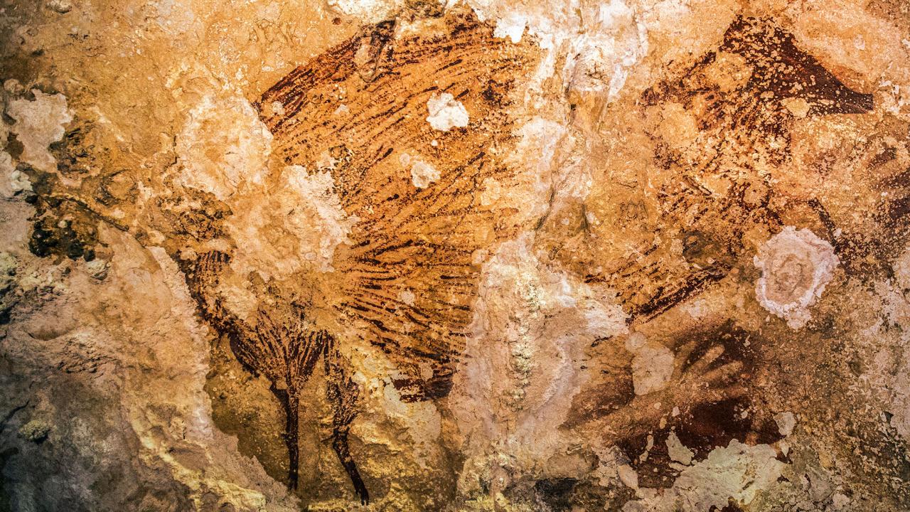 A cave painting in Sulawesi,Indonesia is the oldest known artwork made by humans. Image via Kinez Riza.